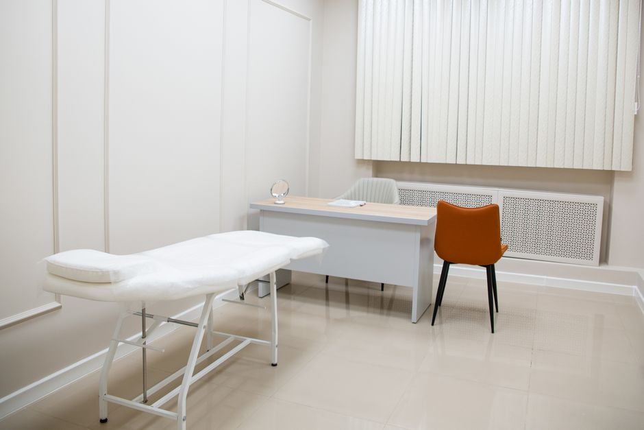 Consultorio médico minimalista y vacío, sin personas, ilustrando la confidencialidad de la consulta por síntomas de una infección de transmisión sexual