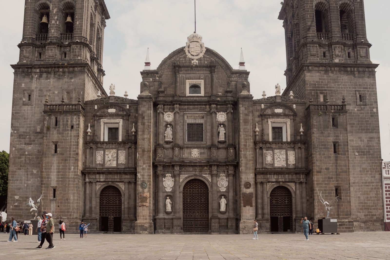 Fachada de catedral colonial de Puebla con personas a la distancia, sin rostros distinguibles