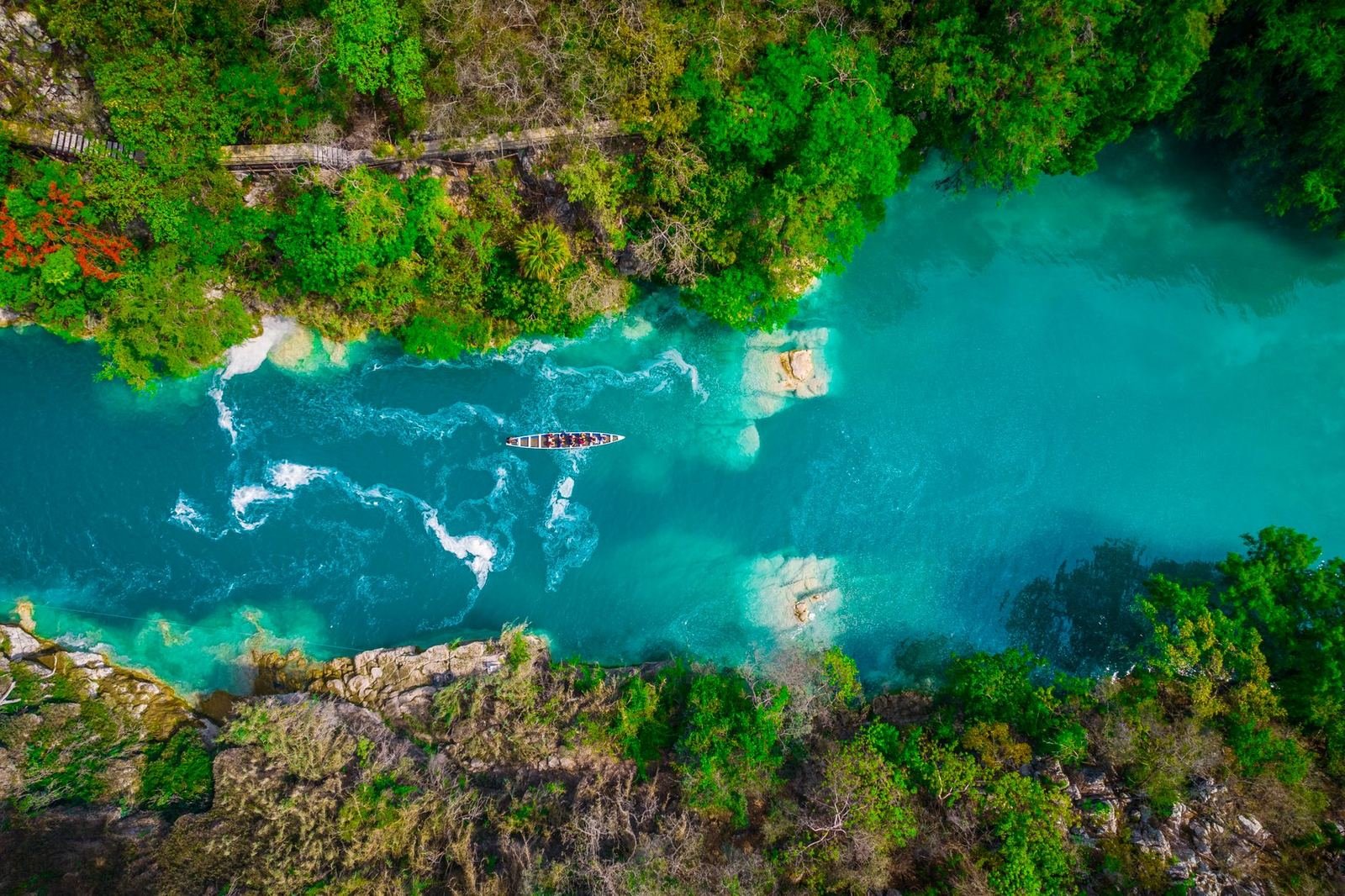 Vista aérea de un río de aguas turquesa entre vegetación verde en la Huasteca potosina, sin rostros visibles