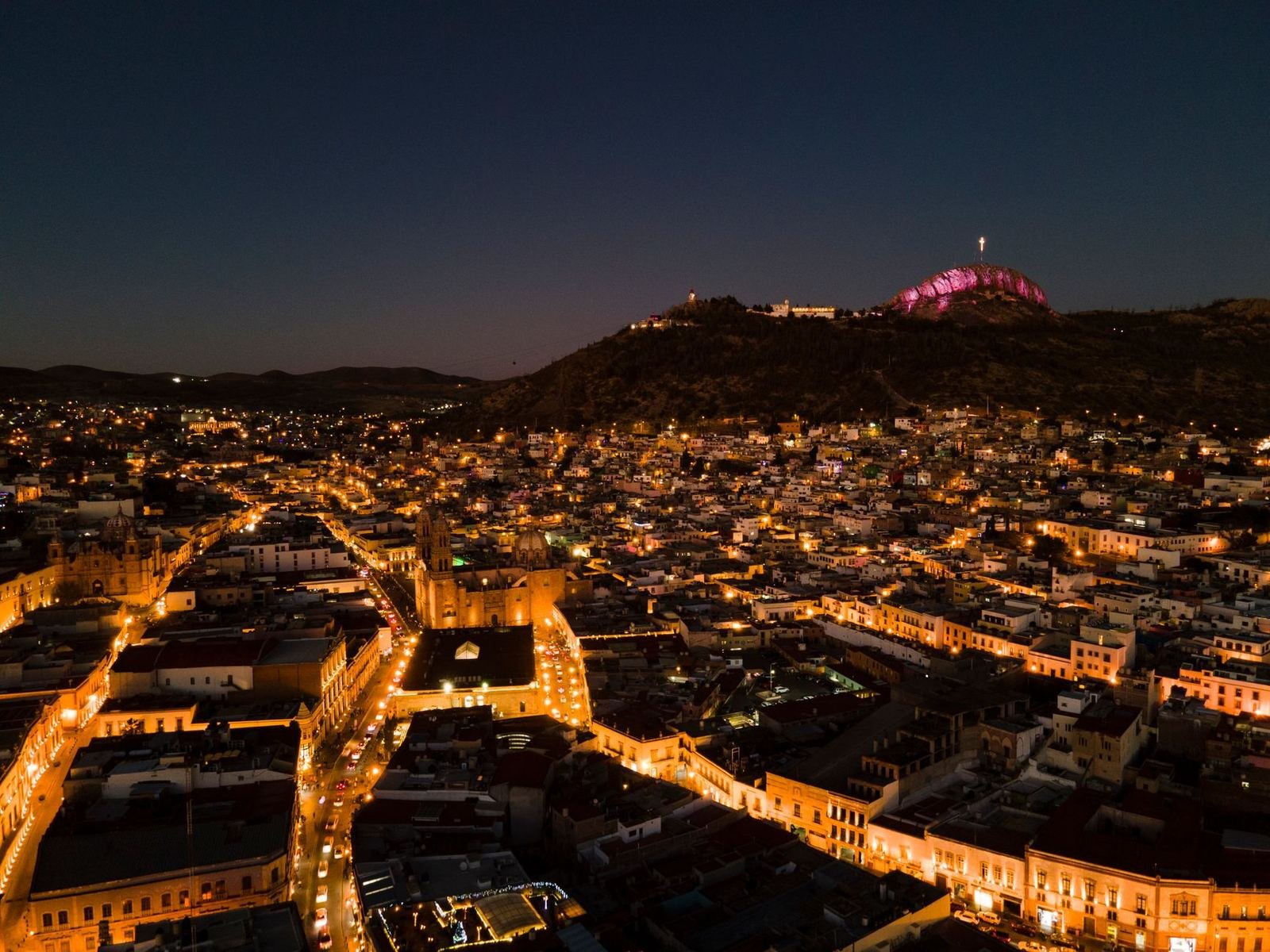 Vista aérea nocturna de la ciudad de Zacatecas con el Cerro de la Bufa iluminado al fondo, sin personas